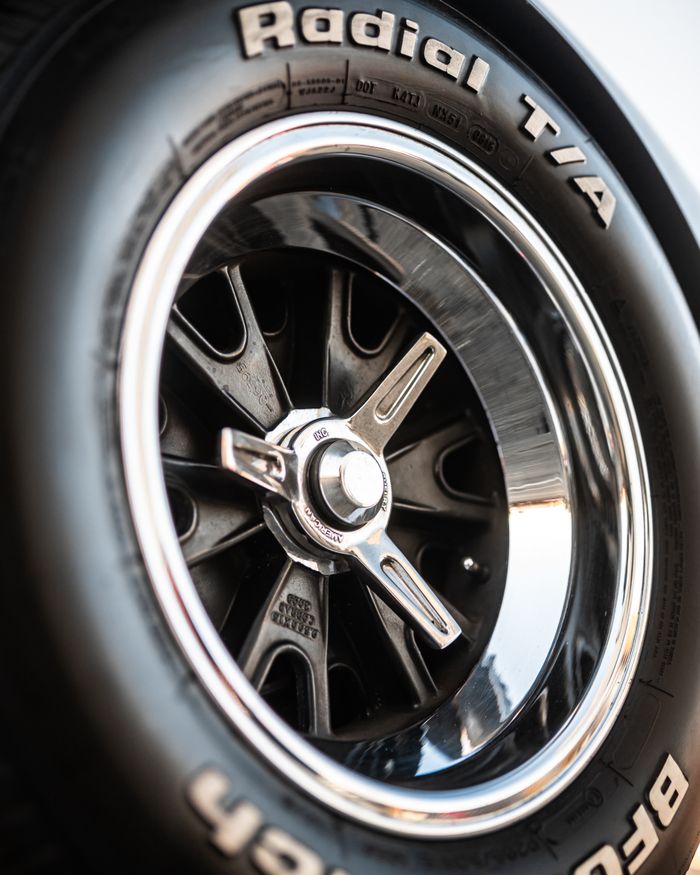 Detailed image of a Radial T/A tire and chrome wheel rim, showcasing its design and texture.
